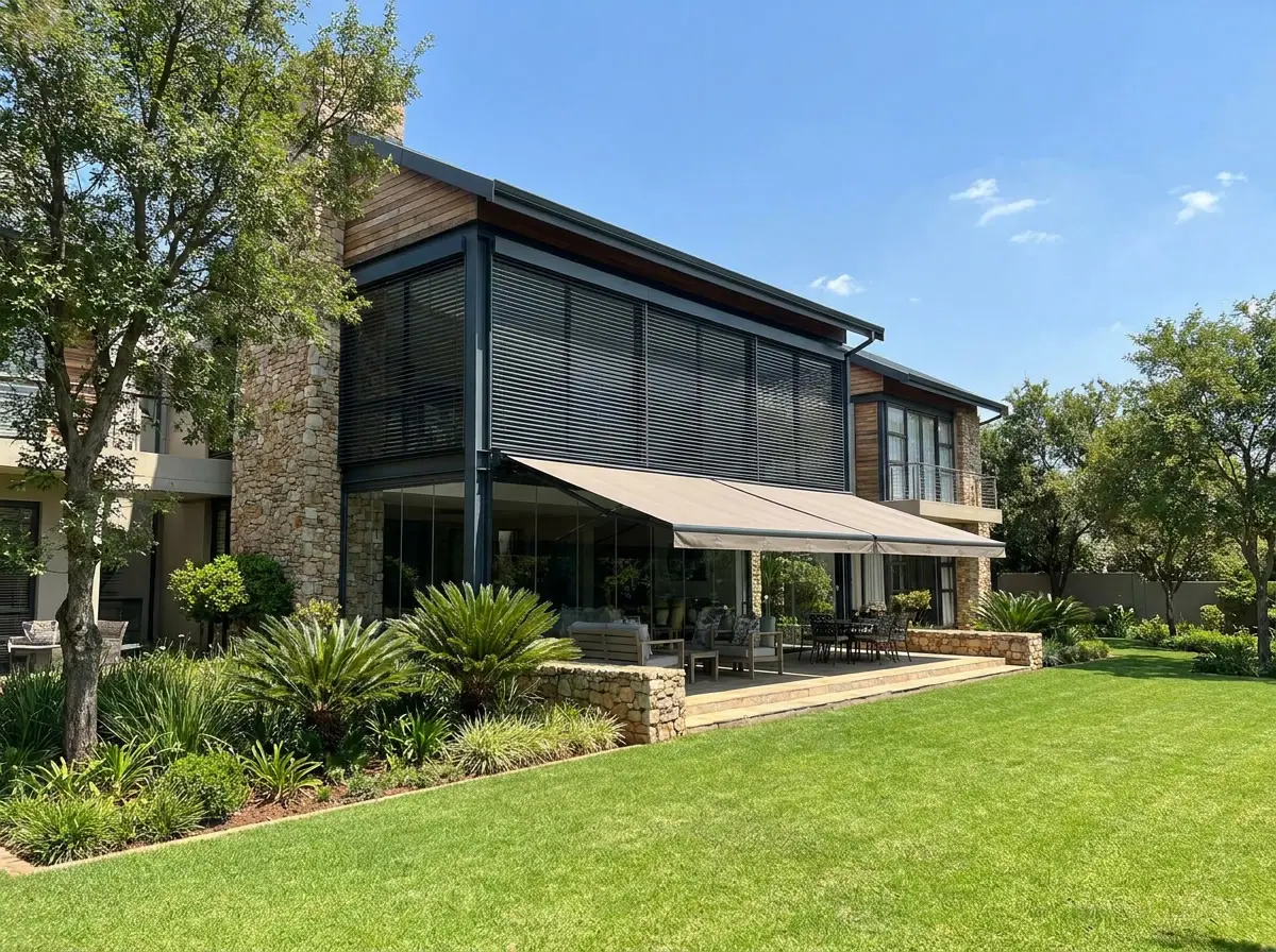 External venetian blinds and folding-arm awning shading a large glazed elevation on a Cornwall Hill stand